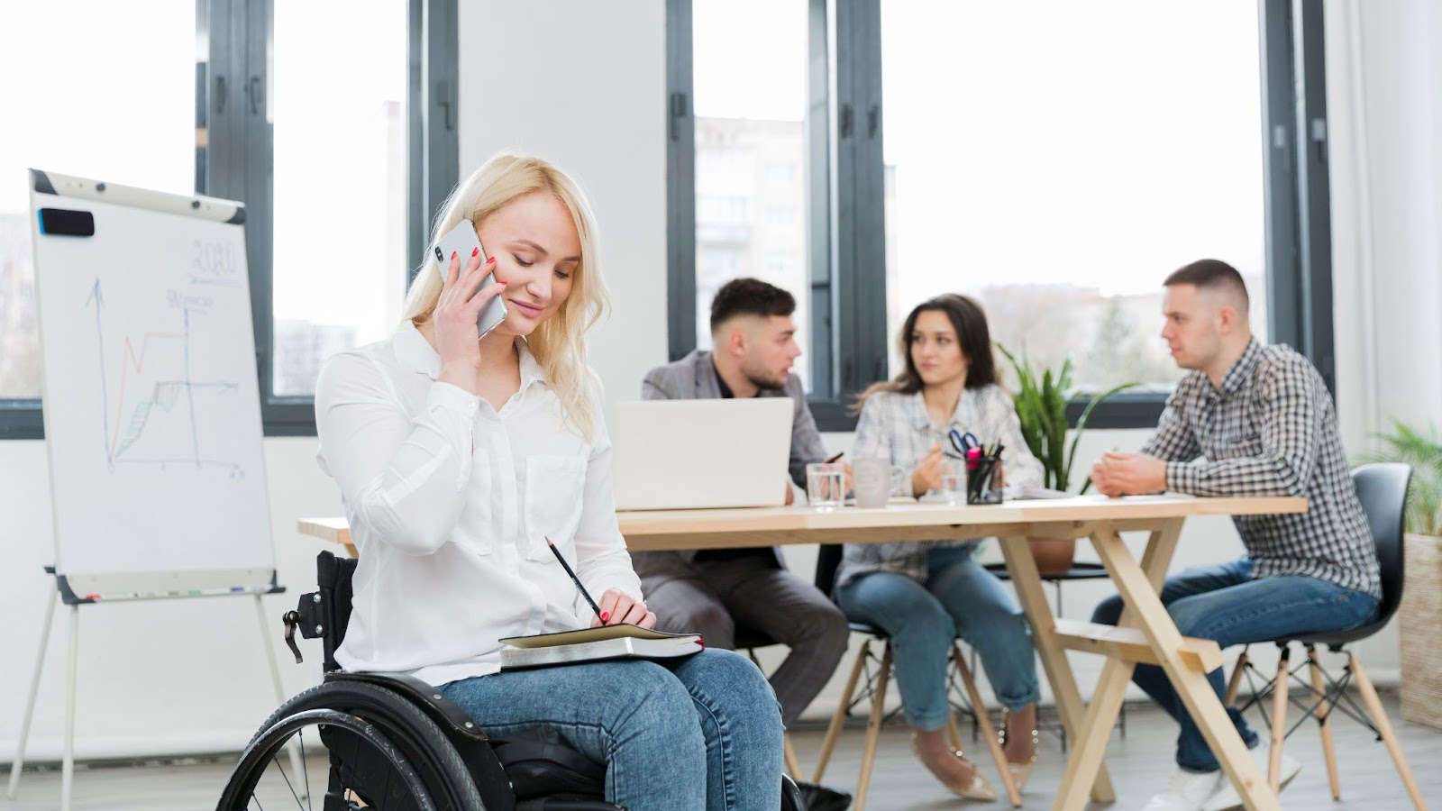 ufficio accessibile donna in sedia a rotelle che lavora